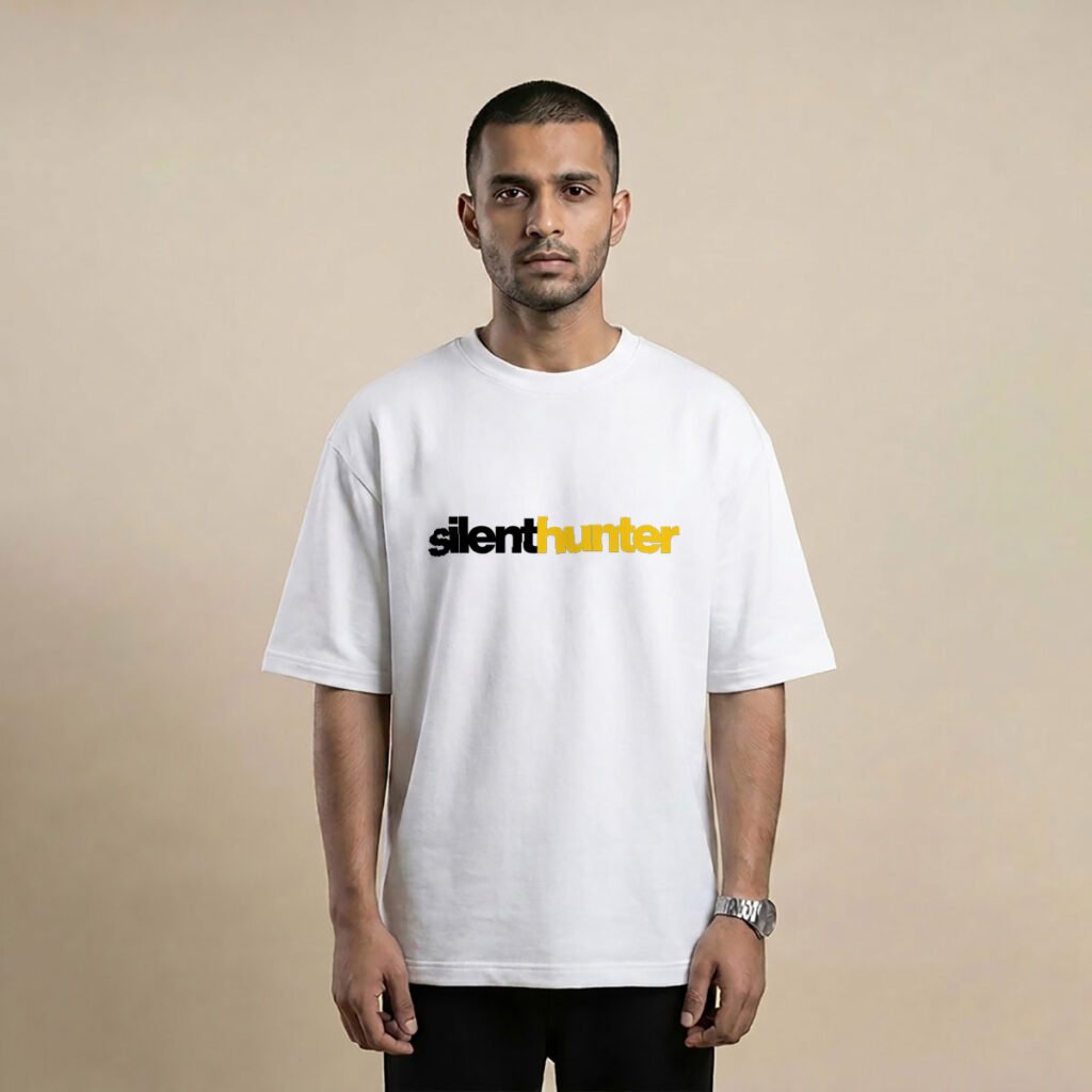Man wearing a white oversized t-shirt with silenthunter printed in black and yellow across the chest