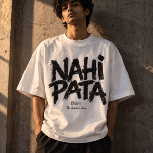 Man in a white Nahi Pata oversized tee with large custom lettering against a raw concrete wall